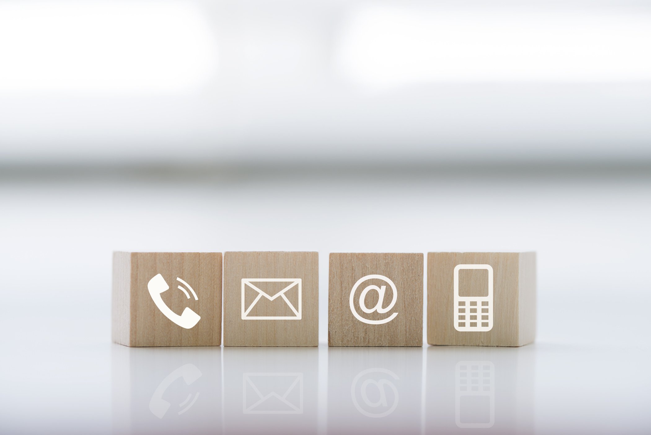 Contact us concept with wood block symbol telephone, mail, address and mobile phone.